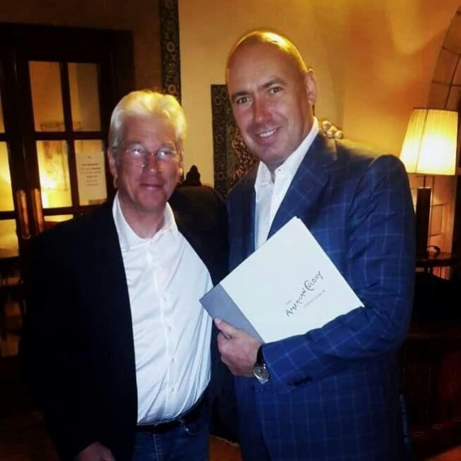 מנכ"ל מלון אמריקן קולוני, תומאס ברונטאלי מעניק את ספר המלון לשחקן ריצ'רד גיר קרדיט צילום: מלון אמריקן קולוני  