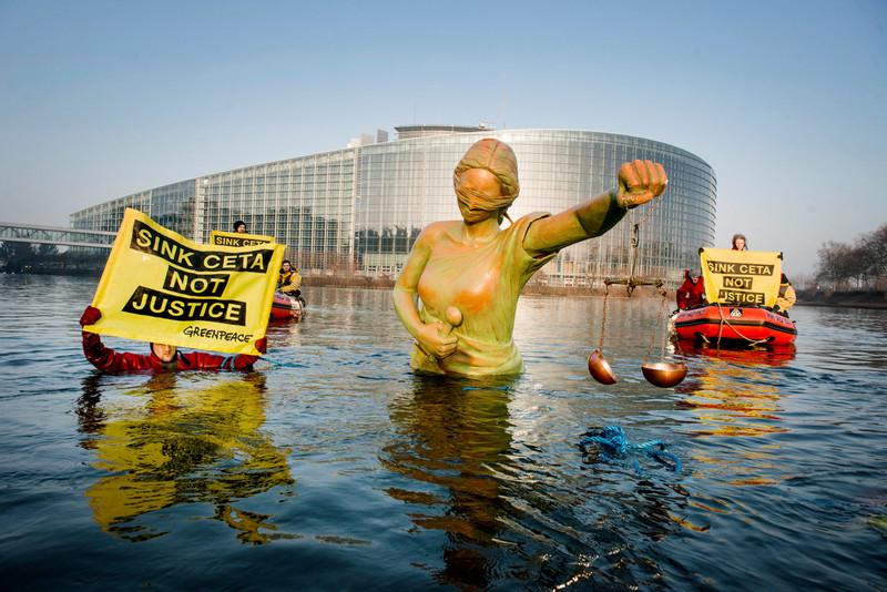 פעילי גרינפיס הציבו מיצג של אלת הצדק במים הקפואים מסביב לפרלמנט האירופי בבריסל