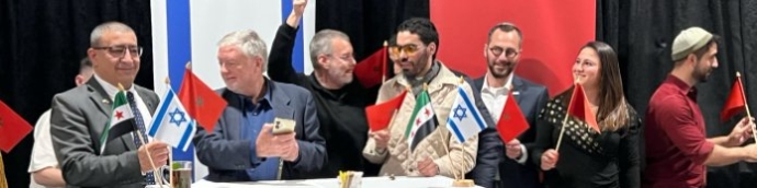 משלחת בין-דתית מניפה זה לצד זה את דגלי ישראל, מרוקו והאופוזיציה הסורית בכינוס של התנועה האברהמית. צילום: Faith & Freedom News