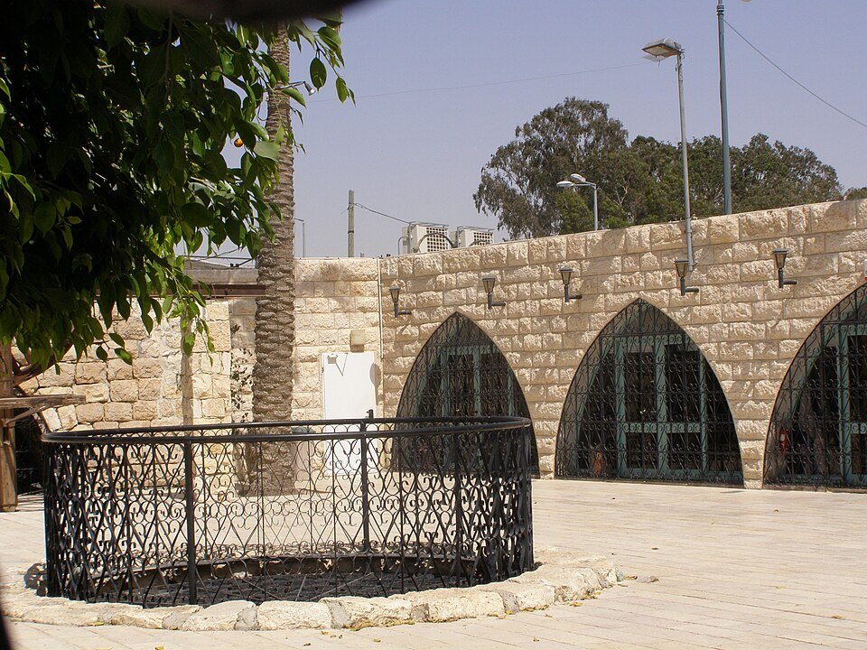 מבנה האבן המקומר של באר אברהם בעיר העתיקה, ובחצרו טבעת הבאר