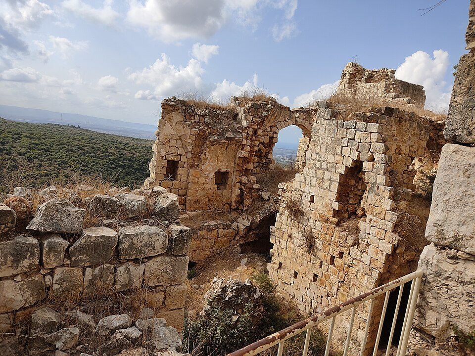 שרידי חומות וחלונות קשתיים במצודת יחיעם על רקע גבעות הגליל