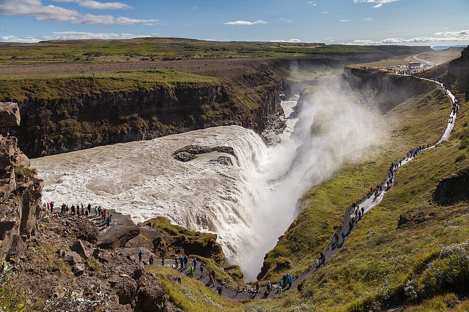 מפל גולפוס הכפול צונח לתוך קניון צר בנוף קיץ ירוק