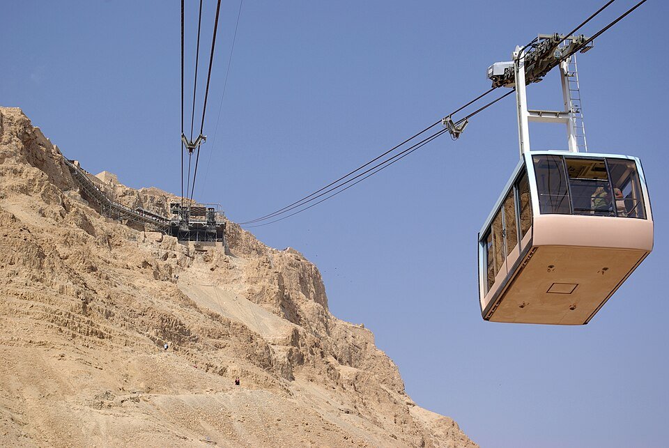 קרון הרכבל של מצדה מטפס לאורך הכבל אל ראש המצוק