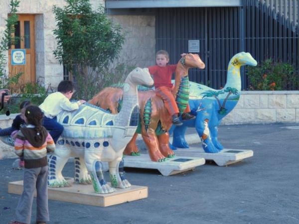 ילדים מטפסים על פסלי דינוזאורים צבעוניים בחצר מדעטק בחיפה (צילום: זאב זמיר, ויקישיתוף, CC BY 2.5)