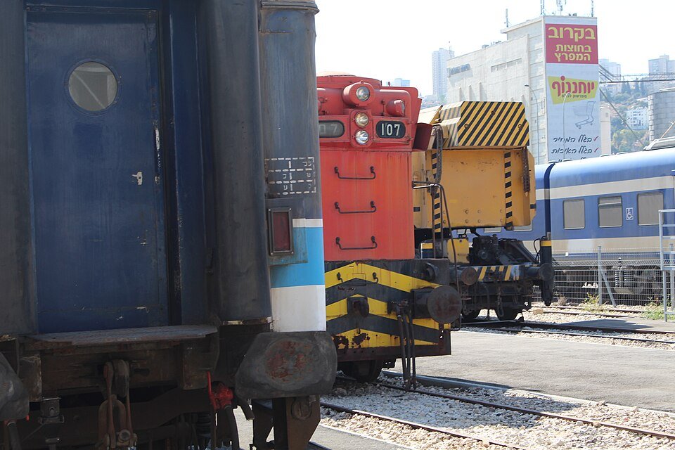 קרונות וציוד מסילה היסטוריים בחצר מוזיאון הרכבת בחיפה