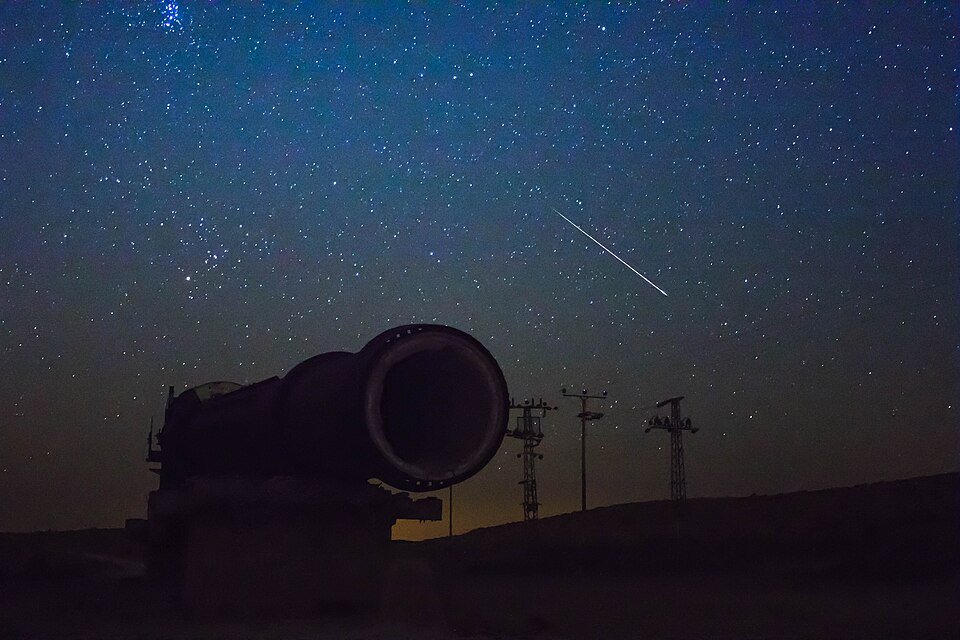 שמי לילה כהים מעל צללית של מתקן בשטח, בצילום ממטר המטאורים של 2016 (צילום: מינוזיג, ויקישיתוף, CC BY-SA 4.0)