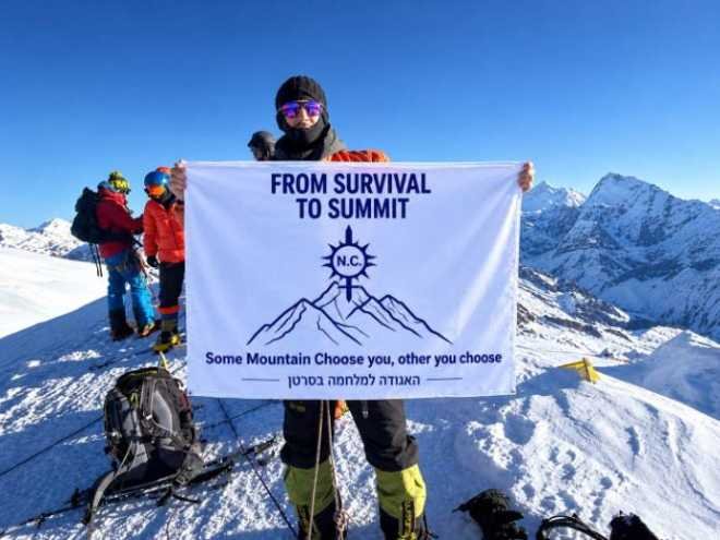 תומר בסן על פסגת מרה בהרי ההימלאיה, עם שלט “From Survival to Summit” | צילום: אור בסן