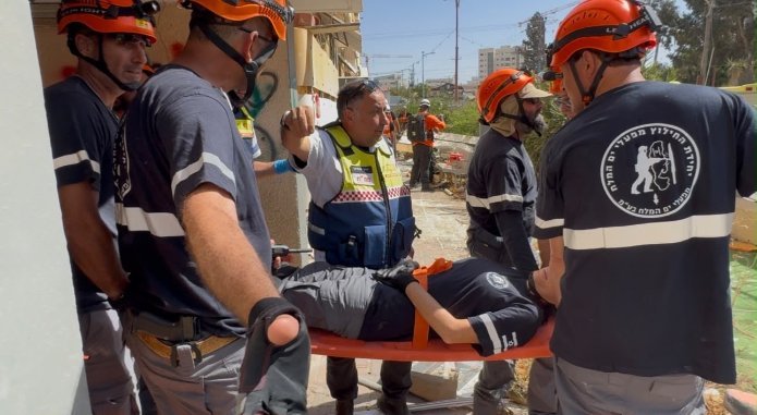 צוותי מד"א וכוחות החילוץ מעניקים טיפול רפואי לנפגע מדומה שחולץ מהמבנה בתרגיל בדימונה | צילום: דוברות מד"א